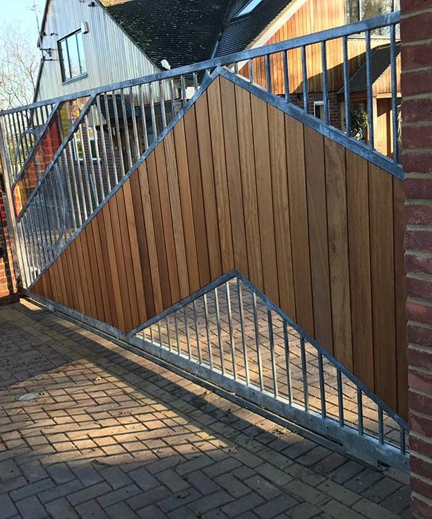 A wooden gate with a metal gate in front of a brick house - Patron Security Ltd