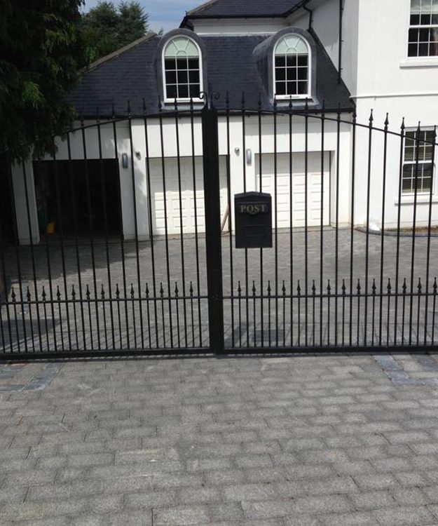 A black wrought iron gate in front of a house - Patron Security Ltd