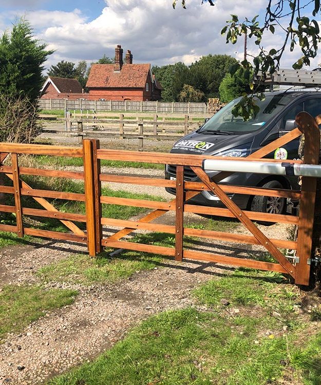 Patron Security Ltd's van is parked next to a wooden gate