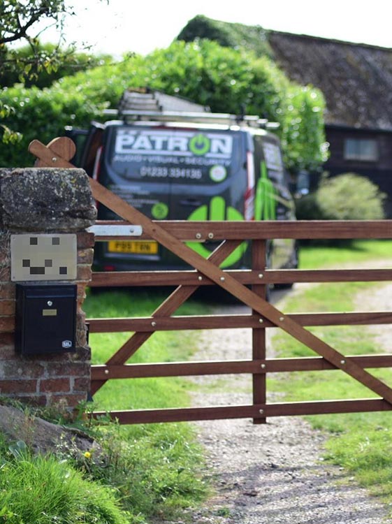 A wooden gate with a mailbox in front of it - Patron Security Ltd